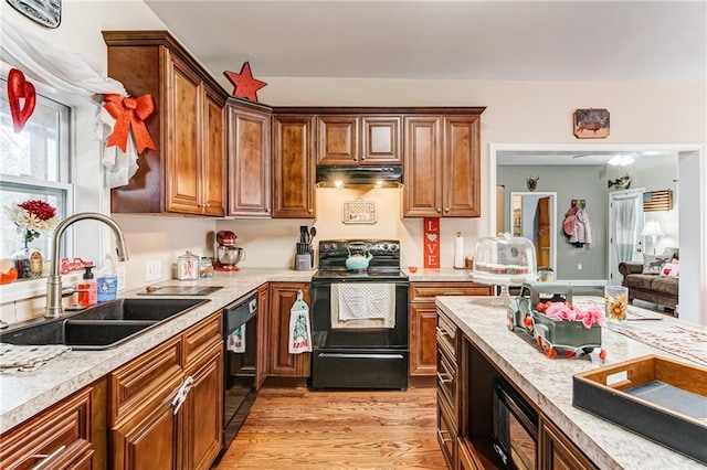 kitchen featuring sink, light hardwood / wood-style floors, and black appliances