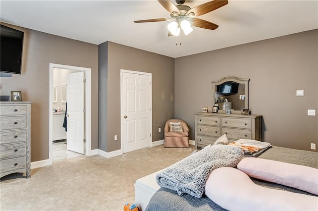 bedroom with light carpet, ensuite bath, and ceiling fan