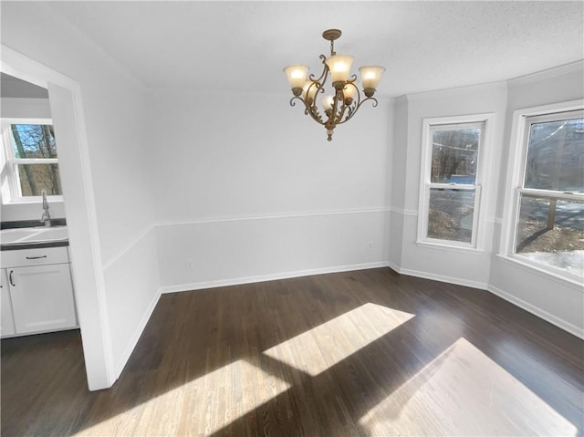 unfurnished dining area with sink, dark hardwood / wood-style floors, and a chandelier