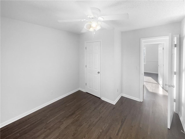 empty room featuring a textured ceiling, ceiling fan, and dark hardwood / wood-style floors