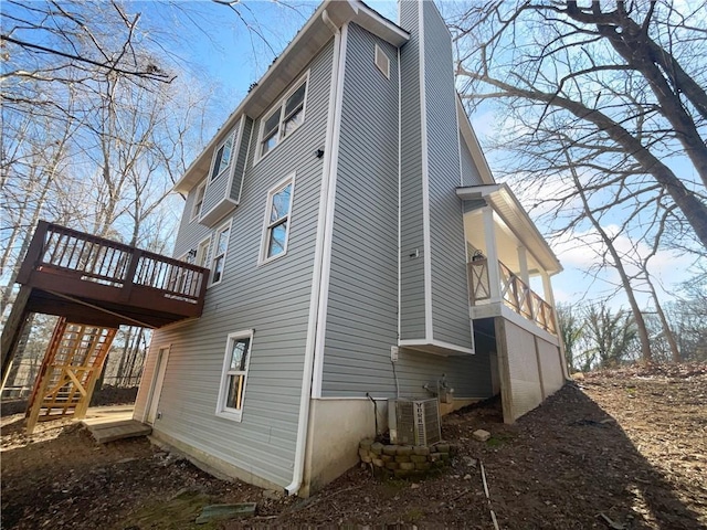 view of side of property with a wooden deck and central air condition unit