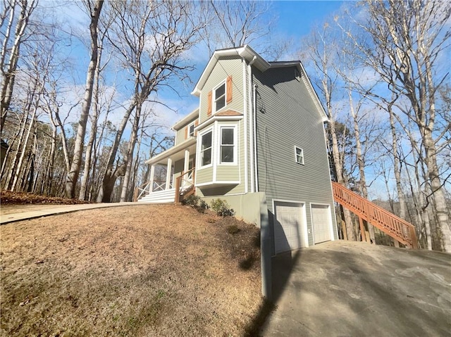 view of side of home featuring covered porch and a garage