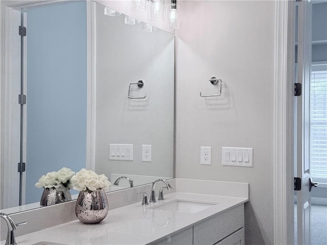 full bathroom with a sink, double vanity, and a healthy amount of sunlight
