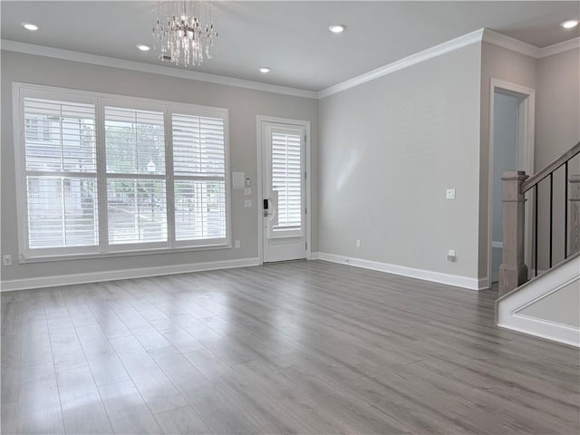 unfurnished living room featuring stairs, ornamental molding, baseboards, a notable chandelier, and dark wood-type flooring