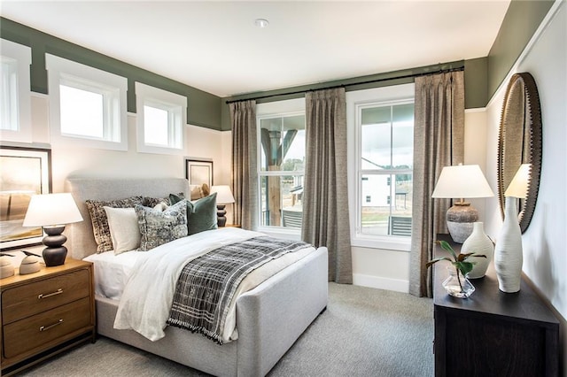 carpeted bedroom featuring multiple windows