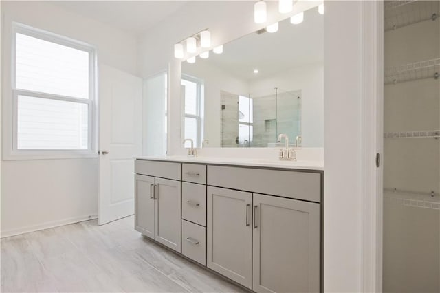 bathroom featuring a shower with shower door and vanity