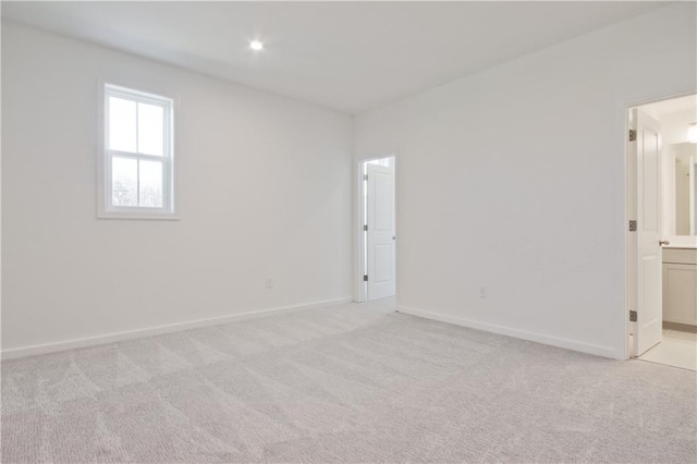 spare room featuring light colored carpet