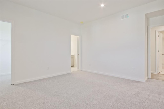 spare room featuring light carpet