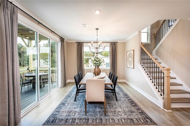 dining room with hardwood / wood-style flooring, a chandelier, and crown molding