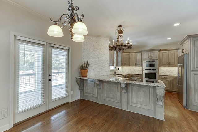 kitchen featuring sink, decorative light fixtures, kitchen peninsula, and decorative backsplash