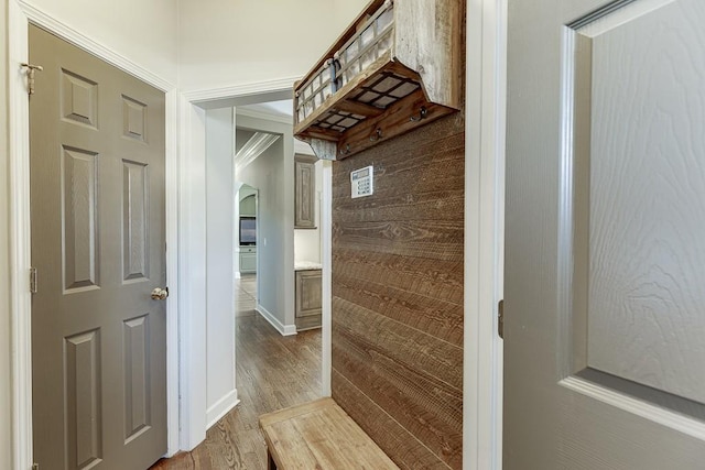 hallway with ornamental molding and light wood-type flooring