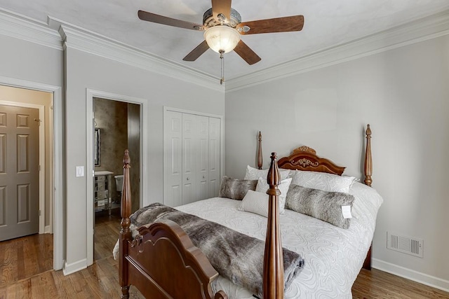 bedroom featuring hardwood / wood-style floors, crown molding, a closet, and ceiling fan