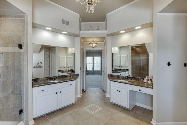 bathroom featuring a shower with door, vanity, and an inviting chandelier