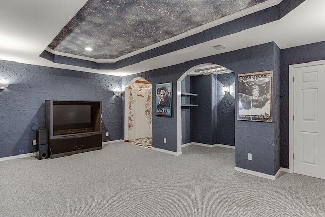 unfurnished living room with a raised ceiling, ornamental molding, and carpet