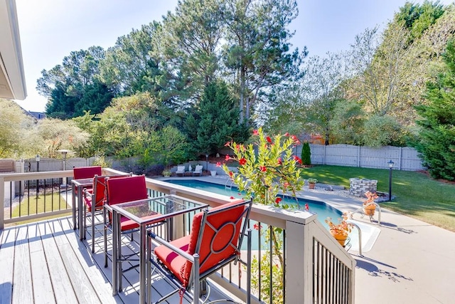 deck with a fenced in pool and a lawn