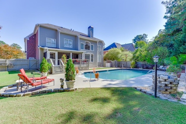 back of house with a yard, a fenced in pool, and a patio area