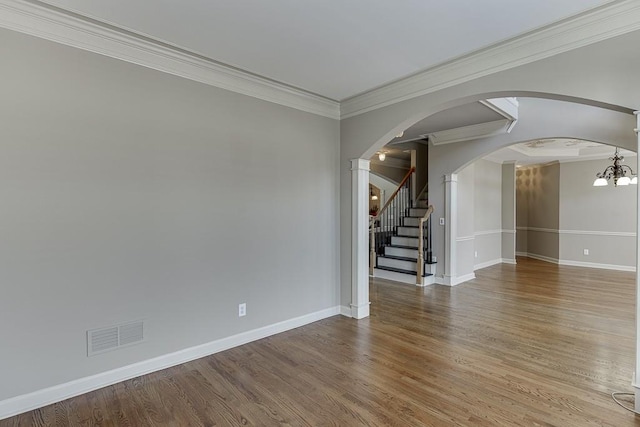 unfurnished room featuring a notable chandelier, crown molding, and hardwood / wood-style flooring