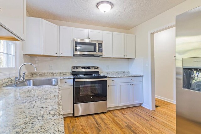 kitchen with white cabinets and appliances with stainless steel finishes