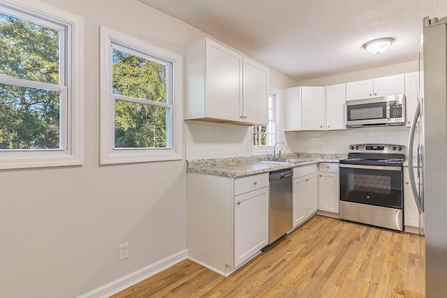 kitchen featuring white cabinets, plenty of natural light, and stainless steel appliances