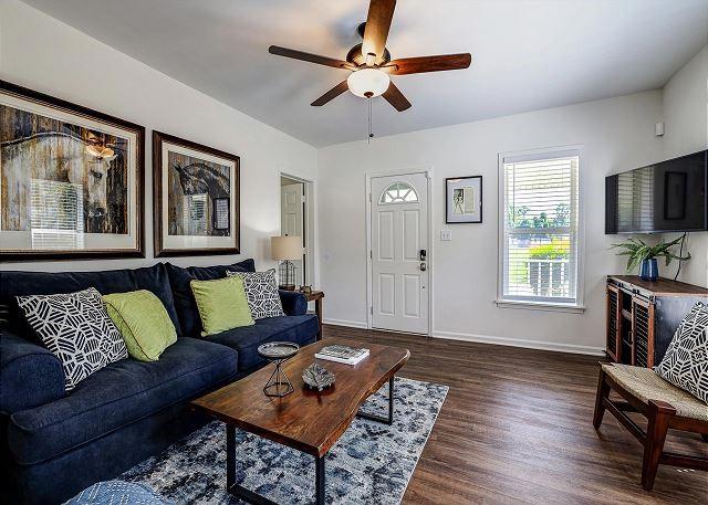 living room featuring wood finished floors, a ceiling fan, and baseboards