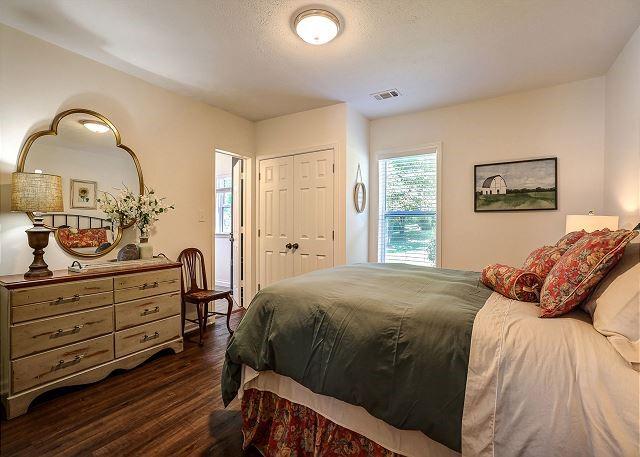 bedroom with dark wood-style floors, a textured ceiling, visible vents, and a closet