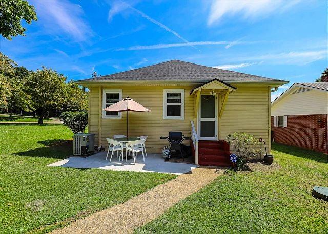 rear view of house featuring entry steps, a patio area, a lawn, and cooling unit