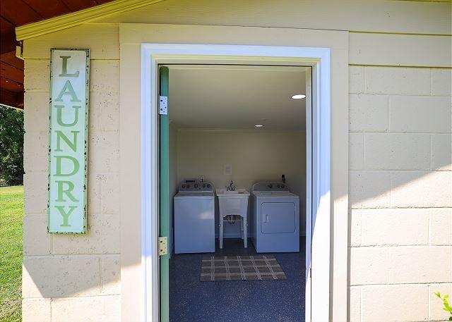 property entrance with concrete block siding, a sink, and washing machine and clothes dryer