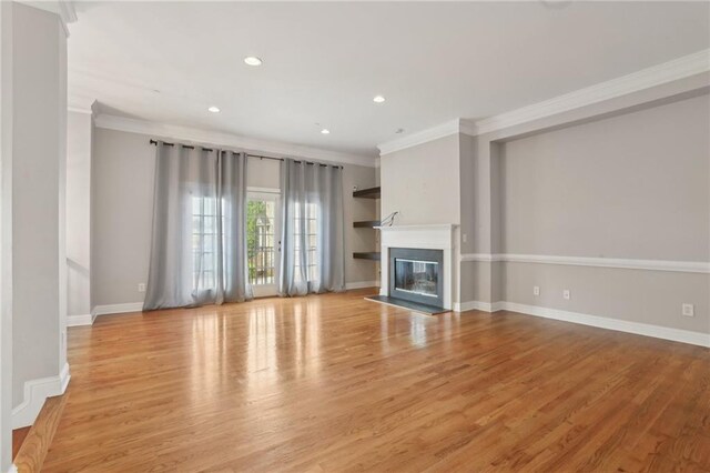 1215 Comet View Trl SE, Smyrna, GA 30082 - unfurnished living room featuring baseboards, light wood finished floors, a glass covered fireplace, ornamental molding, and recessed lighting