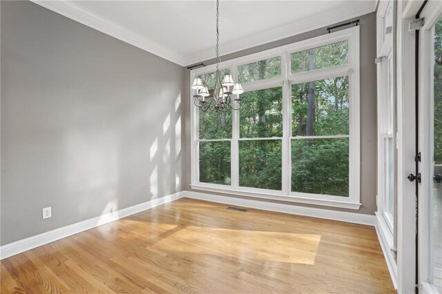 1215 Comet View Trl SE, Smyrna, GA 30082 - unfurnished dining area with a chandelier, baseboards, wood finished floors, visible vents, and ornamental molding