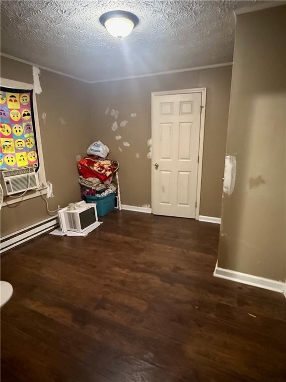 corridor featuring cooling unit, a baseboard radiator, dark hardwood / wood-style floors, and a textured ceiling