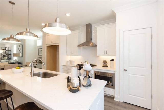 506 Healy Dr Unit 74, Cumming, GA 30040 - kitchen featuring wall chimney range hood, stainless steel microwave, a sink, white cabinetry, and tasteful backsplash