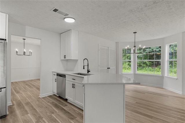 1069 Alford Rd, Lithonia, GA 30058 - kitchen with a chandelier, stainless steel appliances, light wood finished floors, a peninsula, and white cabinetry