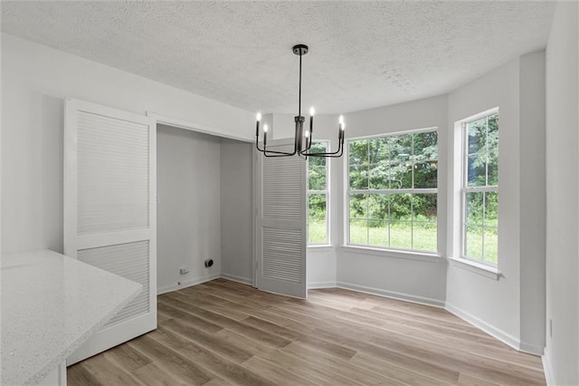 1069 Alford Rd, Lithonia, GA 30058 - unfurnished dining area featuring a chandelier, light wood-type flooring, and a textured ceiling