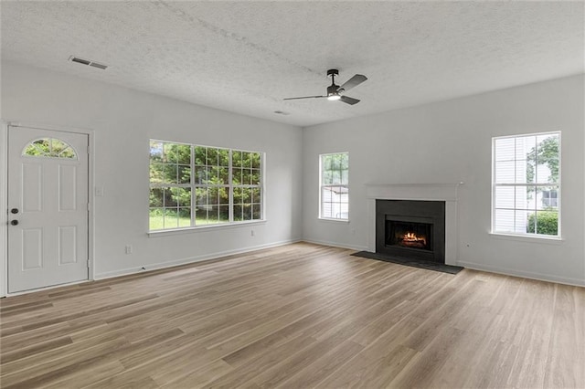 1069 Alford Rd, Lithonia, GA 30058 - unfurnished living room with ceiling fan, light wood-style flooring, a textured ceiling, and a fireplace with flush hearth