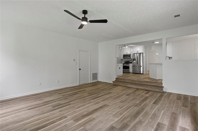 1069 Alford Rd, Lithonia, GA 30058 - unfurnished living room with ceiling fan, light wood-style flooring, and a textured ceiling