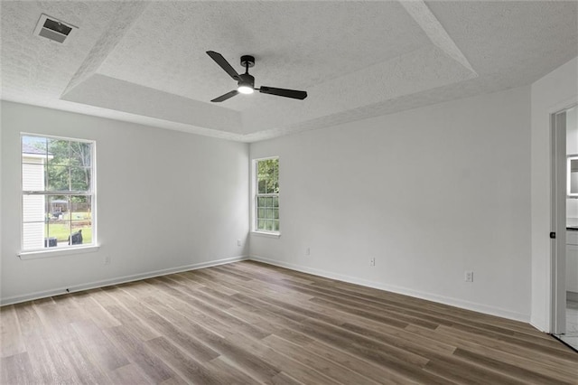 1069 Alford Rd, Lithonia, GA 30058 - empty room featuring a tray ceiling, a textured ceiling, a ceiling fan, and wood finished floors