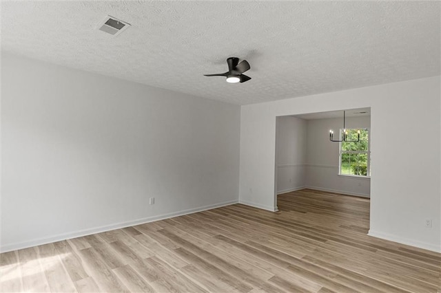 1069 Alford Rd, Lithonia, GA 30058 - empty room featuring light wood-style floors, a textured ceiling, ceiling fan, and a chandelier