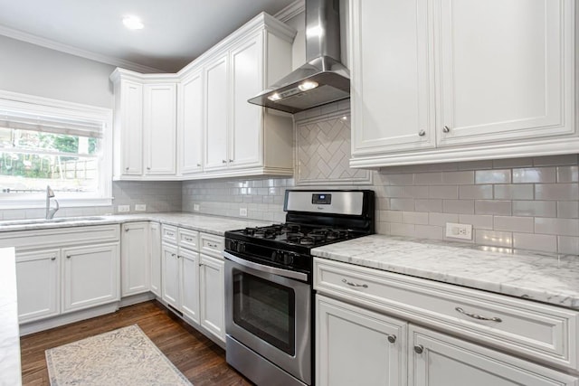 kitchen with dark wood-style floors, a sink, white cabinets, stainless steel gas stove, and wall chimney exhaust hood