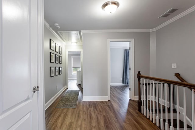 hall with visible vents, attic access, ornamental molding, wood finished floors, and baseboards