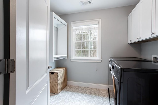 laundry area with washing machine and dryer, visible vents, cabinet space, and baseboards