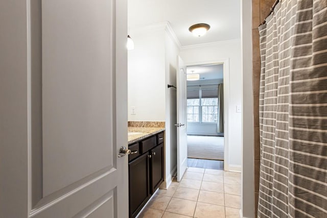 hallway featuring baseboards, ornamental molding, and light tile patterned flooring