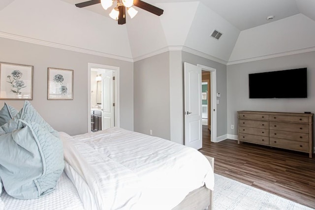 bedroom featuring lofted ceiling, wood finished floors, visible vents, baseboards, and ensuite bath