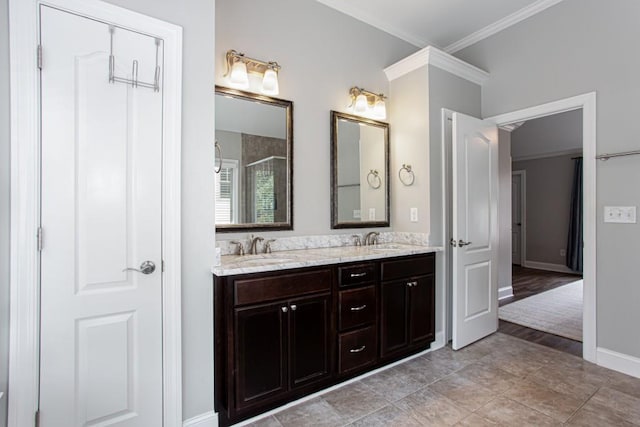 full bathroom featuring crown molding, a sink, baseboards, and double vanity