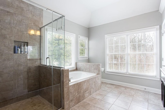 bathroom featuring lofted ceiling, tile patterned flooring, a garden tub, baseboards, and a shower stall