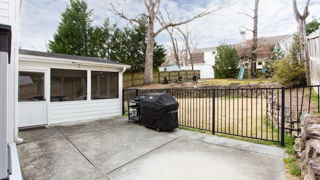 view of patio / terrace featuring a sunroom, a fenced backyard, grilling area, an outbuilding, and a storage unit