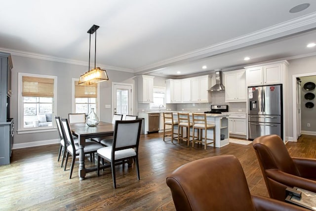 dining space featuring dark wood-type flooring, plenty of natural light, baseboards, and ornamental molding