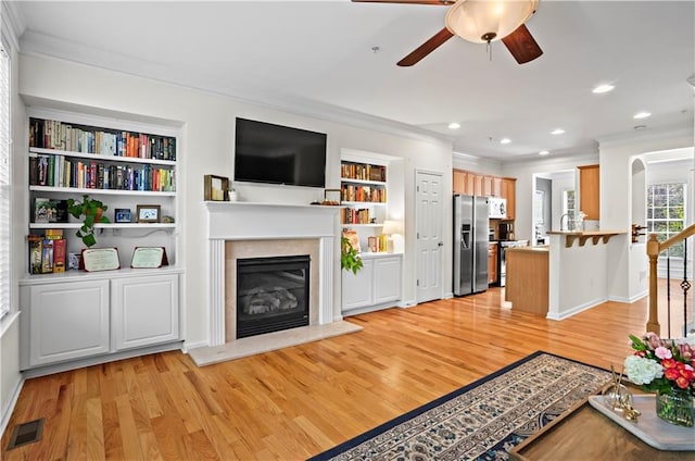 unfurnished living room with visible vents, light wood-type flooring, and crown molding