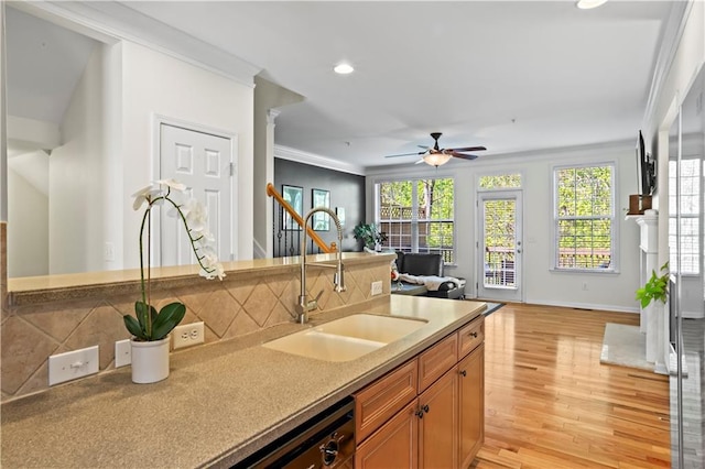 kitchen with recessed lighting, crown molding, light wood-style floors, ceiling fan, and a sink