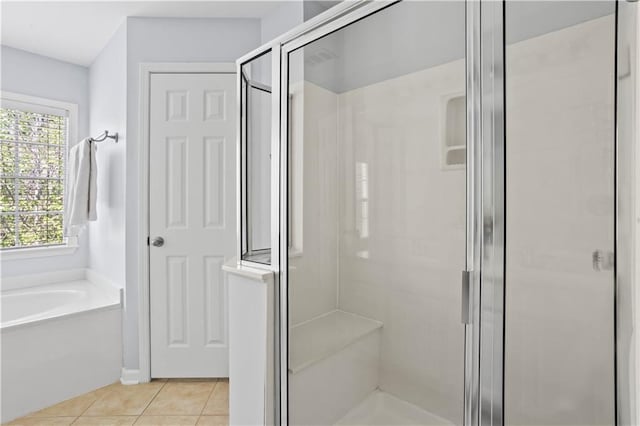bathroom with tile patterned floors, a stall shower, and a garden tub