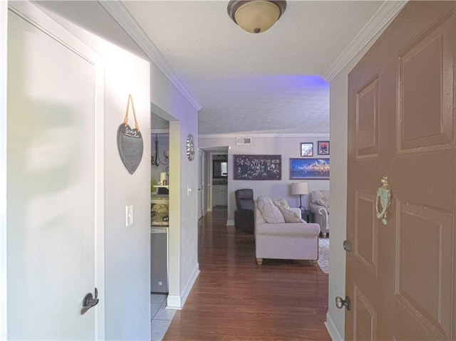 hall with crown molding, a textured ceiling, and hardwood / wood-style flooring